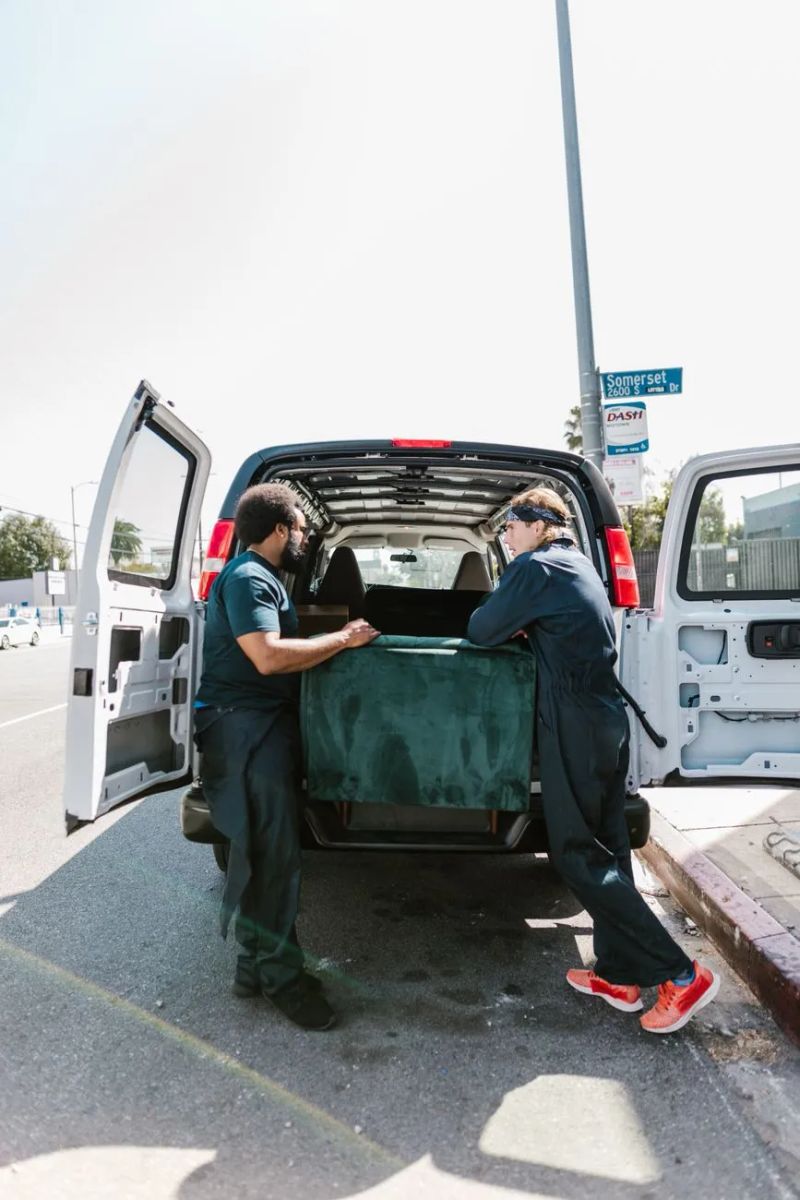 Hunks Junk Removal workers carrying furniture from a Laramie home